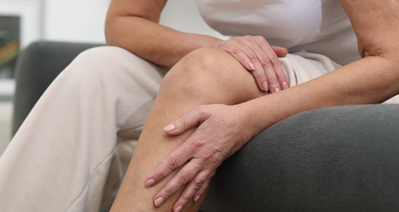 woman holding tired leg