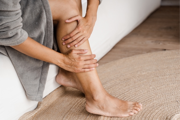 woman sitting on bed examining veins